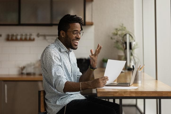 iStock/Excited black man read official letter